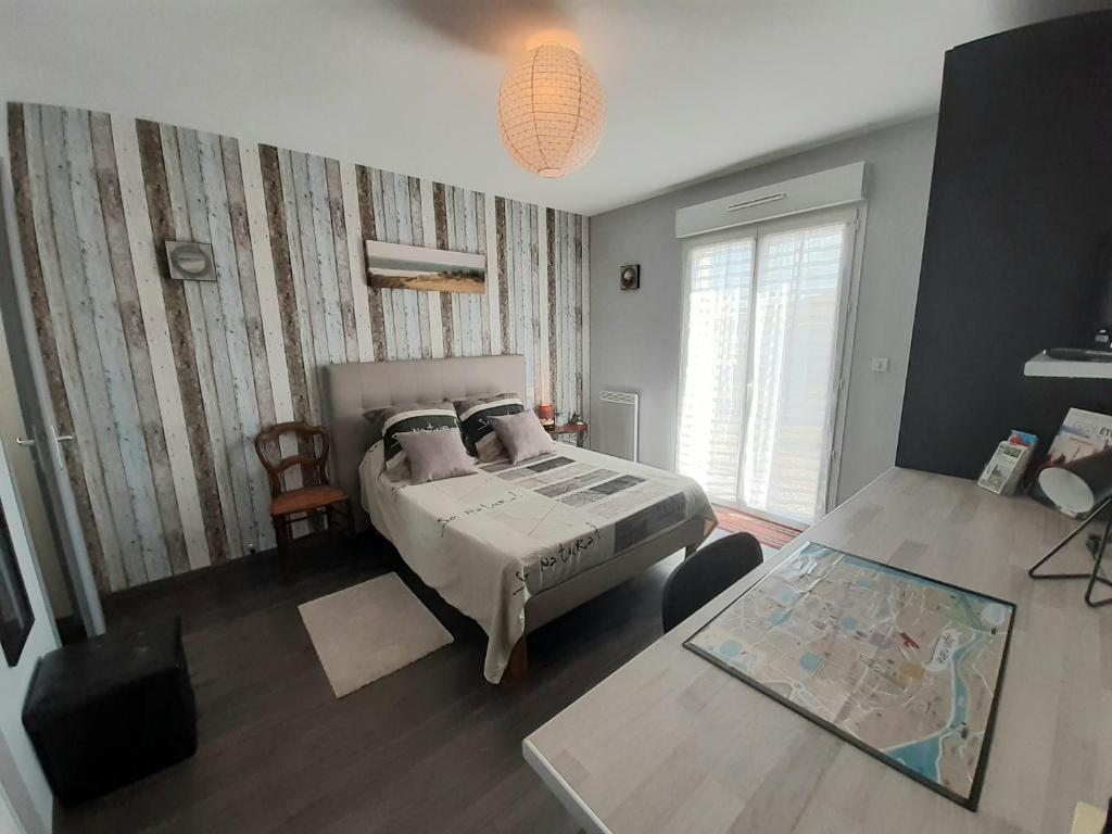 Schlafzimmer mit einem Bett und einem Tisch in der Unterkunft Chambre d'hôtes Les Joncs in Brax