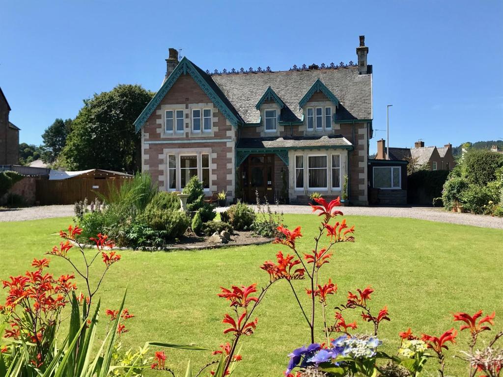 インバネスにあるLairds Lodge Invernessの花の庭のある家