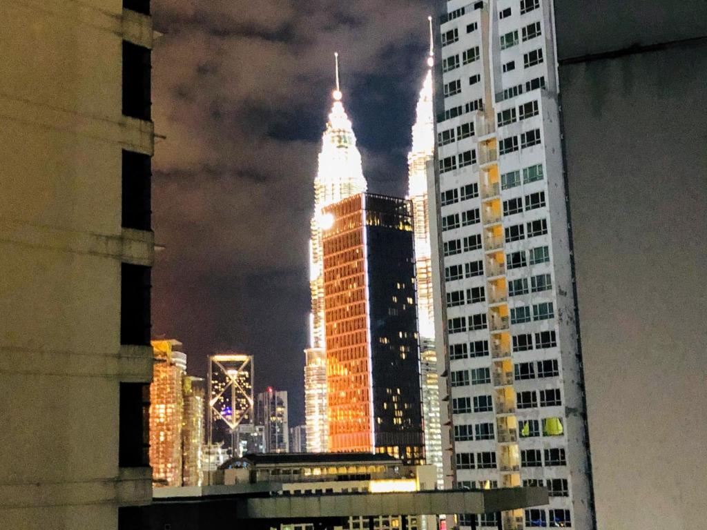 a view of a tall building in a city at night at KLCC One Bedroom apt & Studio in Kuala Lumpur