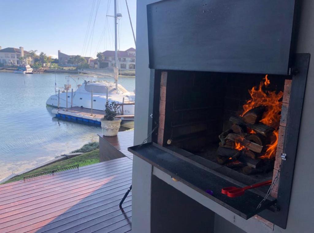 a fireplace with a fire in it next to a boat at RiverView Retreat in Velddrif