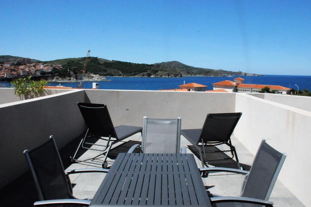 une table et des chaises sur un balcon avec vue sur l'eau dans l'établissement Appartement avec grande terrasse vue sur mer, à Banyuls-sur-Mer