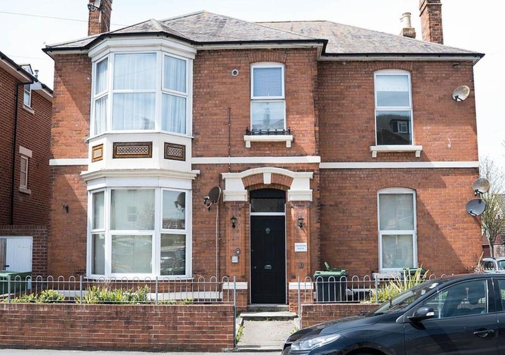 une maison en briques rouges avec une porte noire dans l'établissement Freshford House, à Weymouth