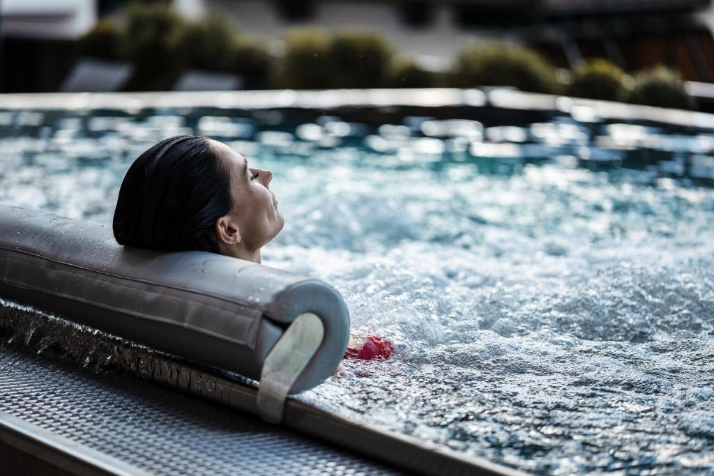 una persona nadando en una piscina en Vier Jahreszeiten Wellnessresort Achensee, en Maurach