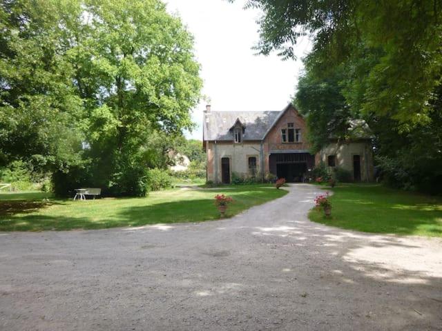 una casa grande con una entrada delante de ella en Suite dans les dépendances du Château, en Agonges