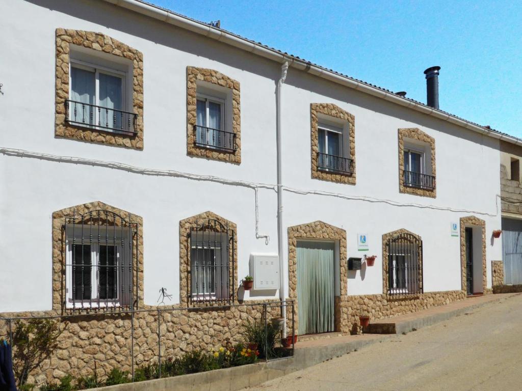 a white building with windows and gates on a street at Vivienda rural casa manoli 