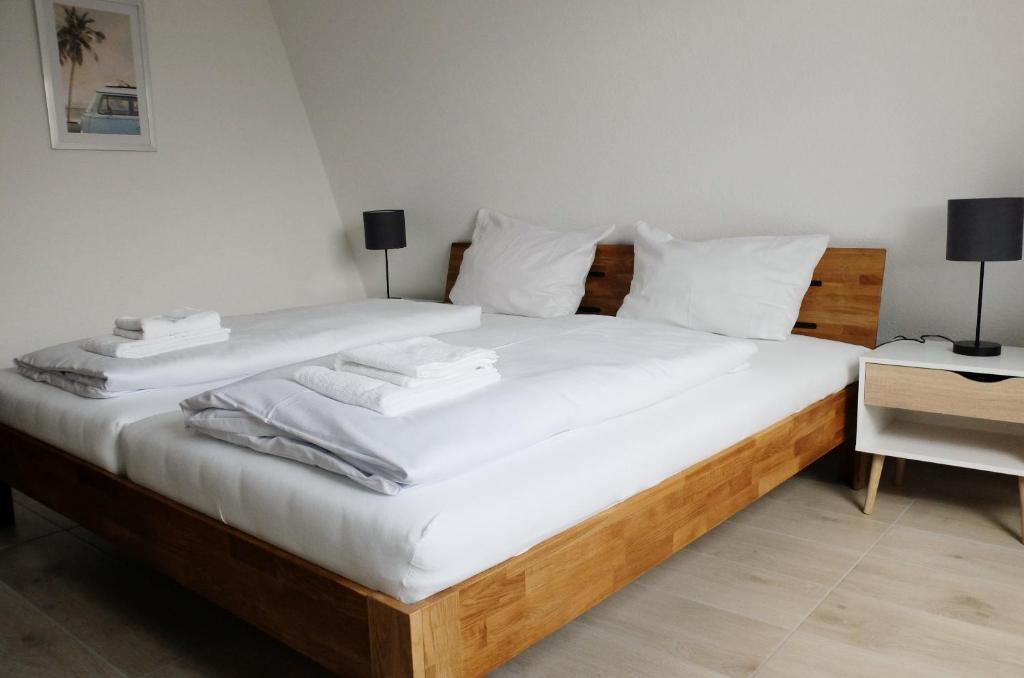 Schlafzimmer mit einem Bett mit weißer Bettwäsche und Handtüchern in der Unterkunft Hotel Calenberger Hof in Wennigsen