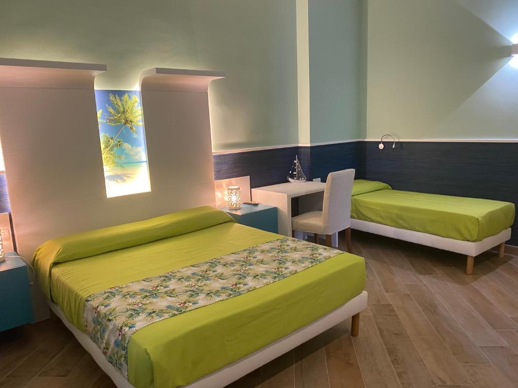 1 dormitorio con 2 camas, mesa y escritorio en Porto di mare b&b, en Giovinazzo