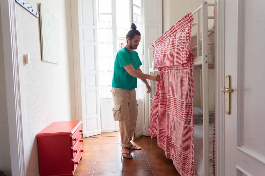 Ein Mann steht vor einem Schrank. in der Unterkunft Onefam Centro in Sevilla