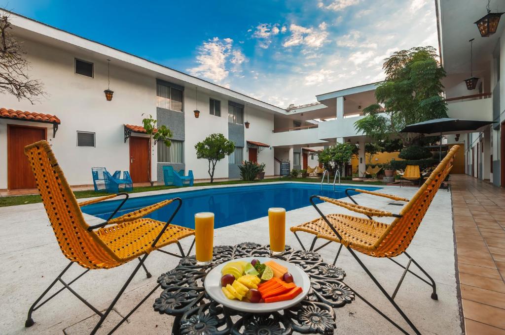 eine Terrasse mit 2 Stühlen und einem Tisch mit einer Obstschale in der Unterkunft Hotel Isabel in Guadalajara