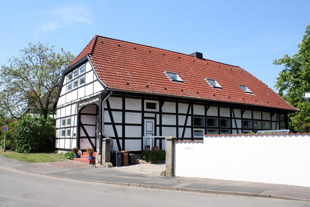 een zwart-wit gebouw met een rood dak bij Suite „Hannover“ - modernes Apartment in Fachwerkhaus in Hannover