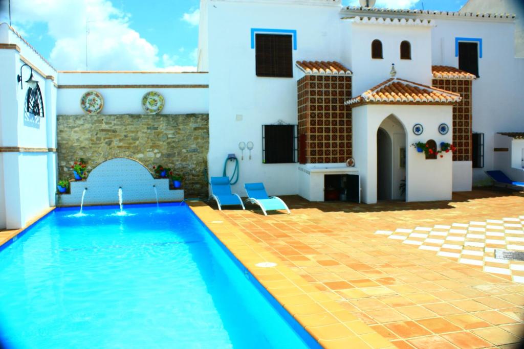 a swimming pool in a courtyard with a white house at La Fabrica De Juan in La Joya