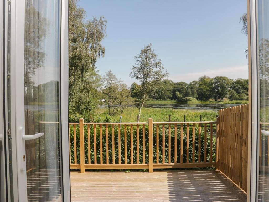 una puerta abierta a un balcón con vistas a un campo en Simply Suite, en Castle Douglas