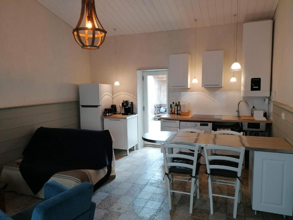 a kitchen and dining room with a table and chairs at L'annexe de Gaston in Le Port-des-Barques