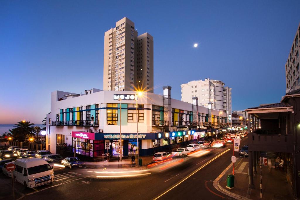 Cape Town的住宿－Mojo Hotel & Market，一条城市街道,晚上有汽车和建筑