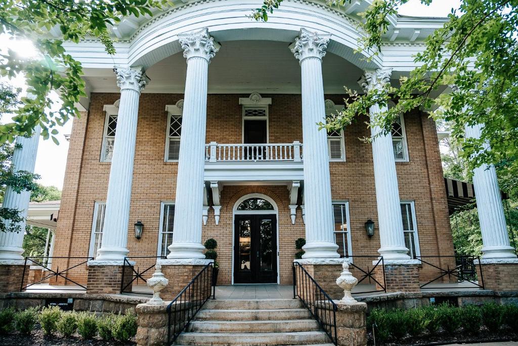 a large brick house with columns and a front door at Heritage House Bed & Breakfast - Boutique Adults-Only Inn in Opelika
