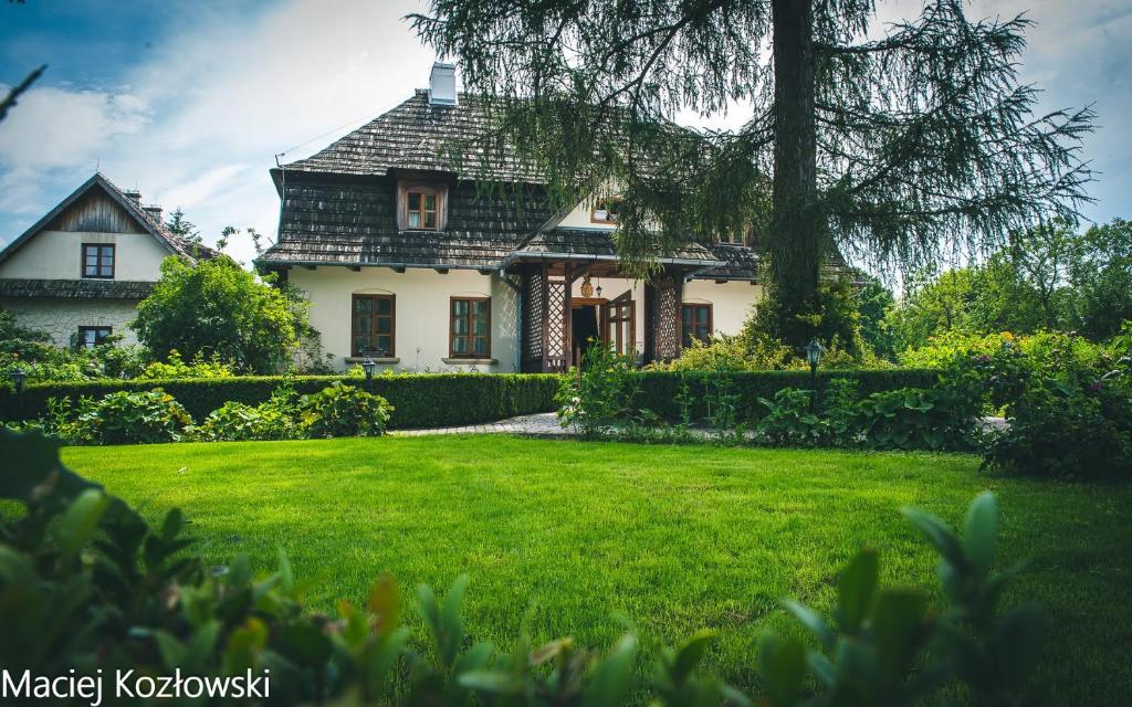 una casa con un césped verde delante de ella en Folwark Walencja, en Kazimierz Dolny
