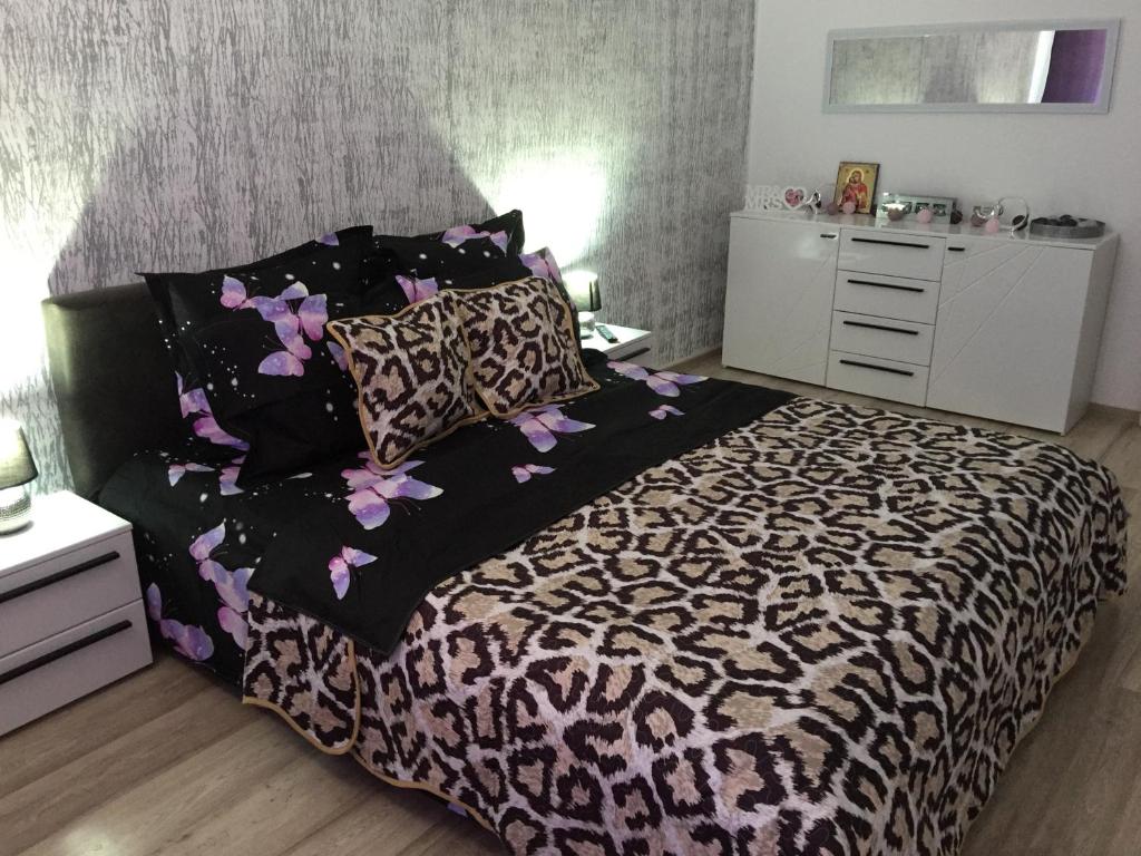 1 dormitorio con 1 cama con edredón blanco y negro en Apartament Mady & Ary Rasnov, en Râșnov