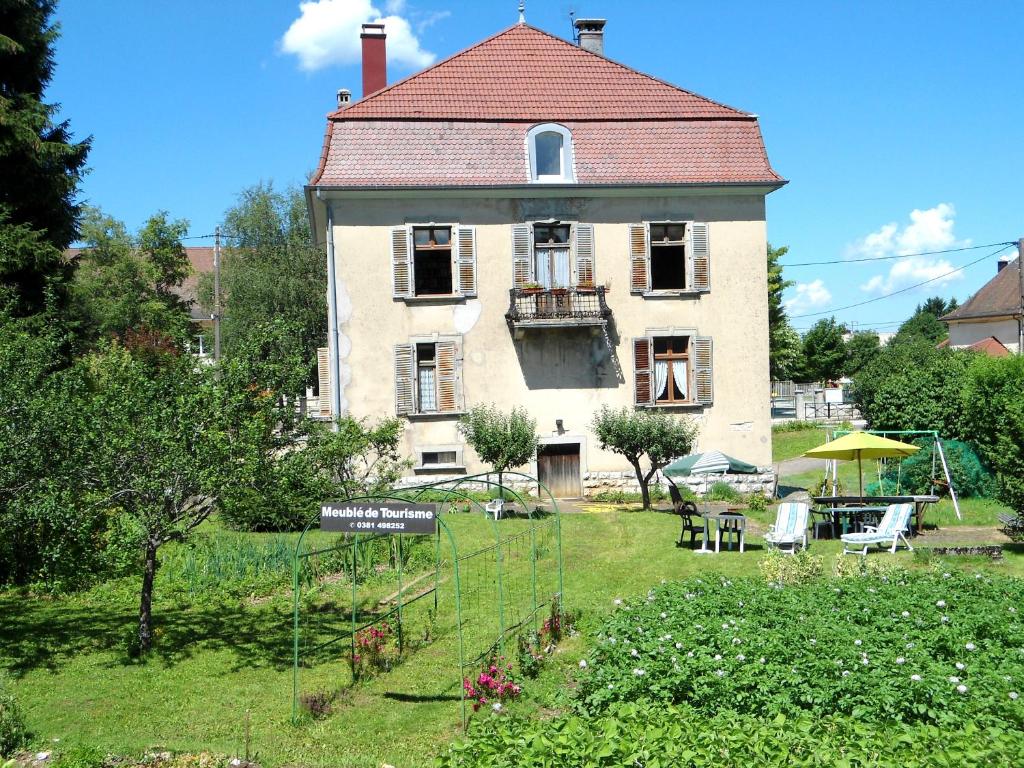 a large house with a garden in front of it at Meublé de tourisme in Frasne