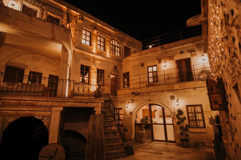 ein altes Steingebäude mit einer Treppe und einem Balkon in der Unterkunft Cappadocia Eagle Cave Inn in Nevşehir
