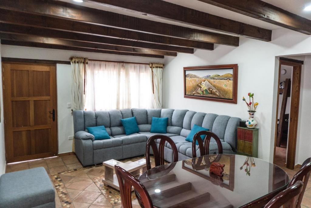 un soggiorno con divano blu e tavolo di Apartamento Madeiro a Villa de Leyva