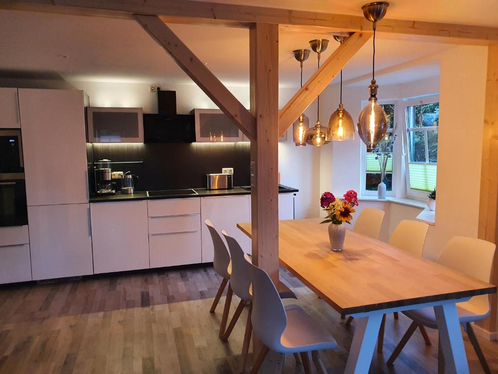 uma cozinha e sala de jantar com uma mesa de madeira e cadeiras em Gute Laune Hof Klingenthal em Klingenthal