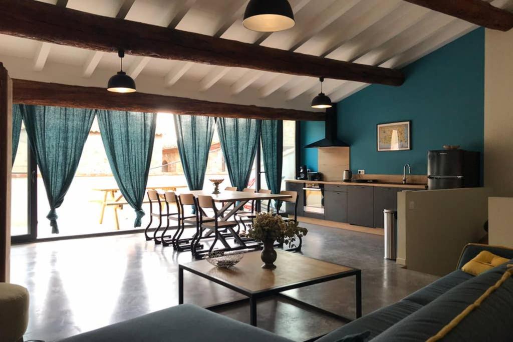 Gîte de charme du Domaine Pagnon Guillemette في توراي: غرفة معيشة مع طاولة وكراسي ومطبخ