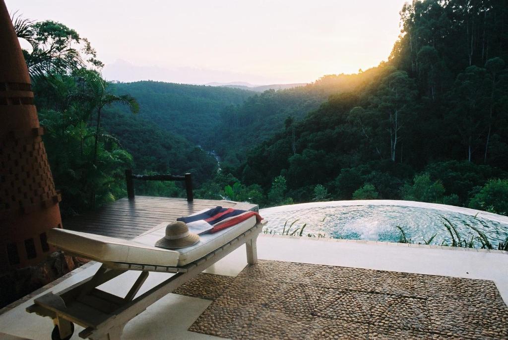 a bench sitting on a balcony with a view of a mountain at Timamoon Lodge in Hazyview