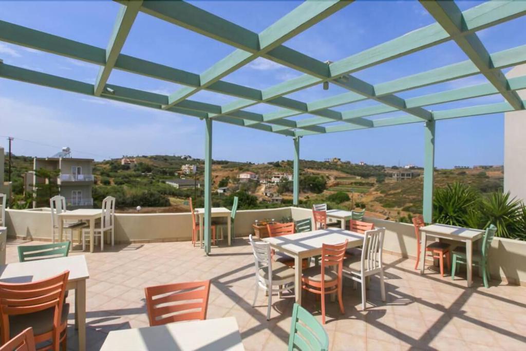 a patio with tables and chairs on a roof at Pelagia Bay Hotel in Agia Pelagia