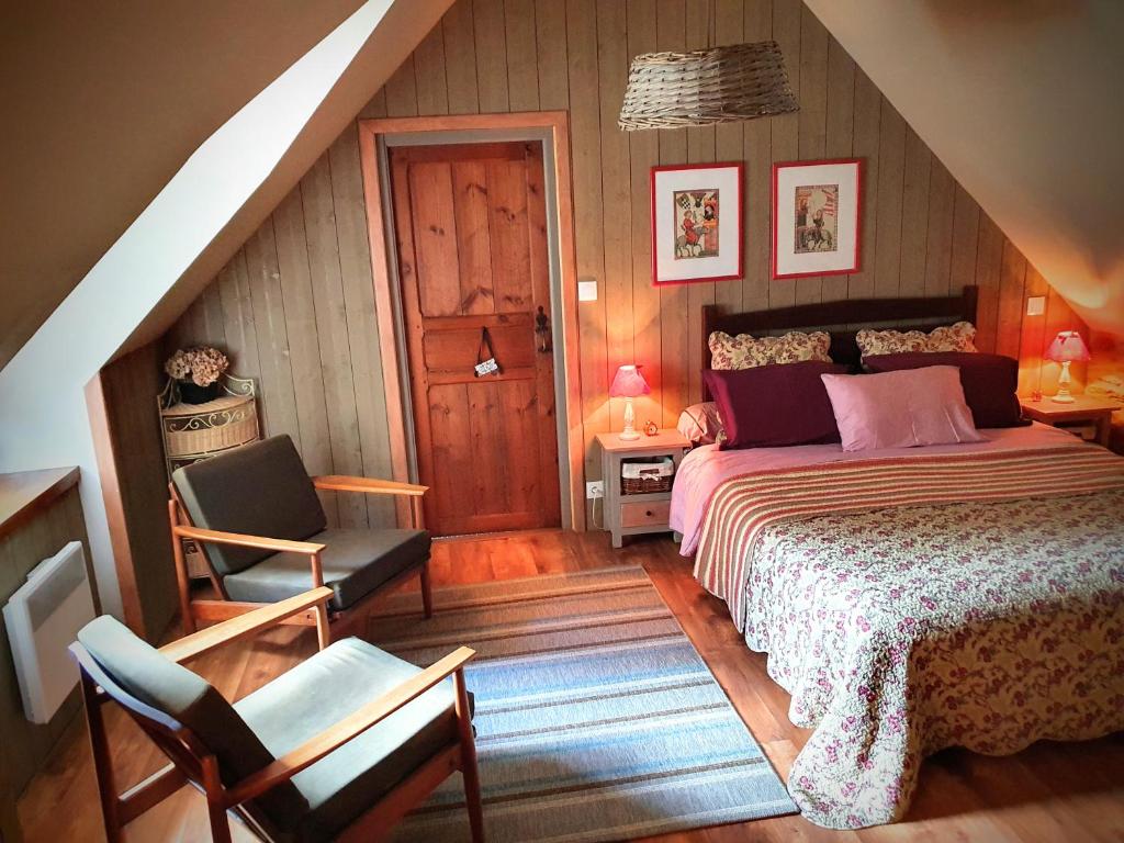 a bedroom with a bed and a chair in a attic at Le Triskelium in Landebaëron