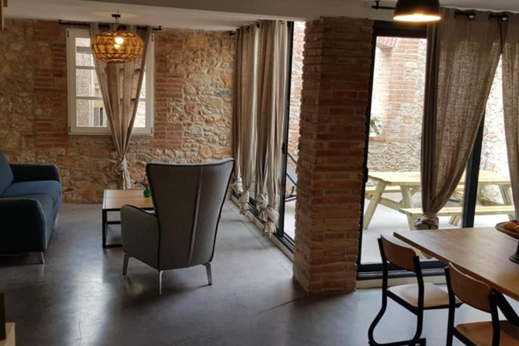 sala de estar con sofá, mesa y sillas en Gîte de charme du Domaine Pagnon Frigoulette, en Torreilles