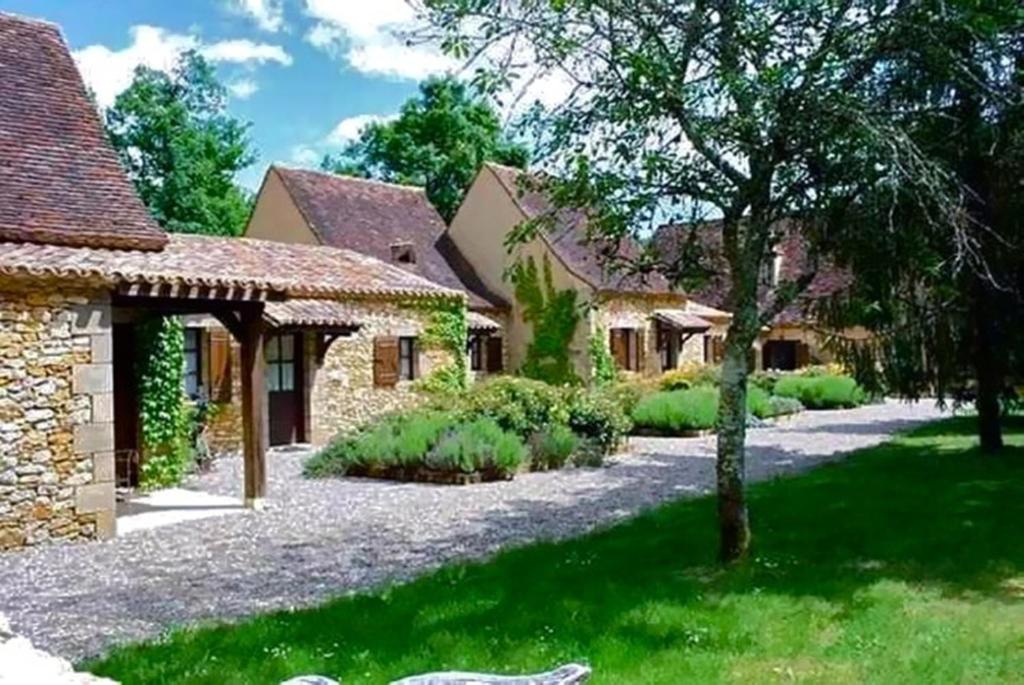 una casa con una entrada de grava frente a un patio en Le Domaine de La Millasserie, en Mauzac-et-Grand-Castang