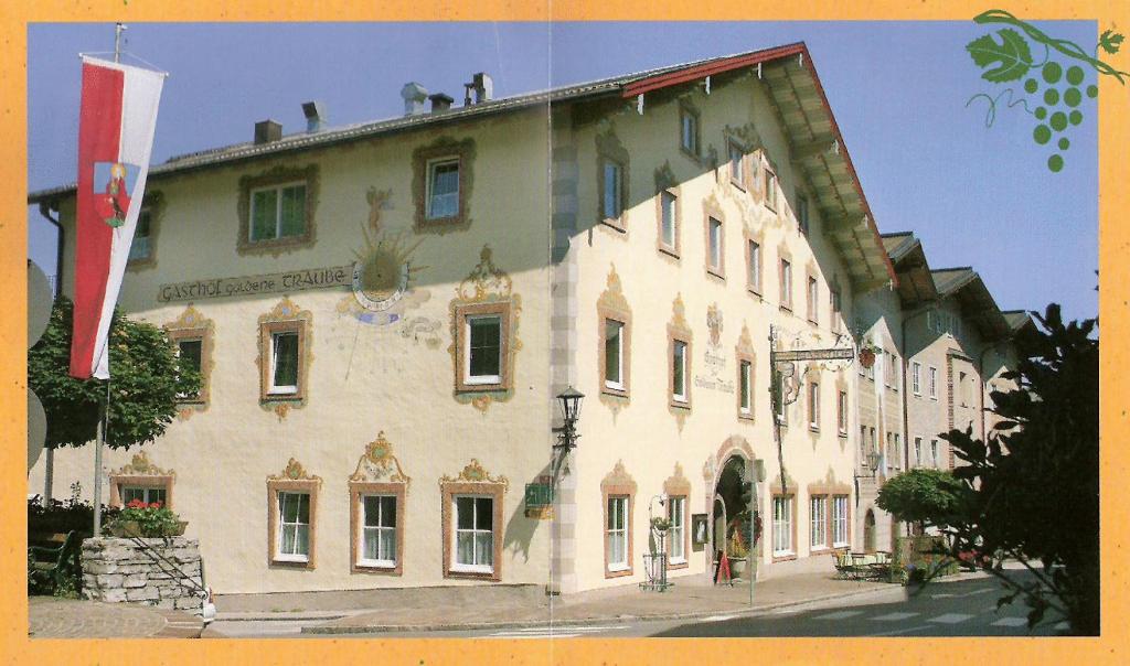 un grande edificio con una bandiera di fronte di Gasthof Goldene Traube a Golling an der Salzach
