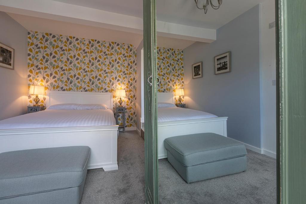a bedroom with two beds and a mirror at The Sleep-Inn Hare B&B in Herne Bay