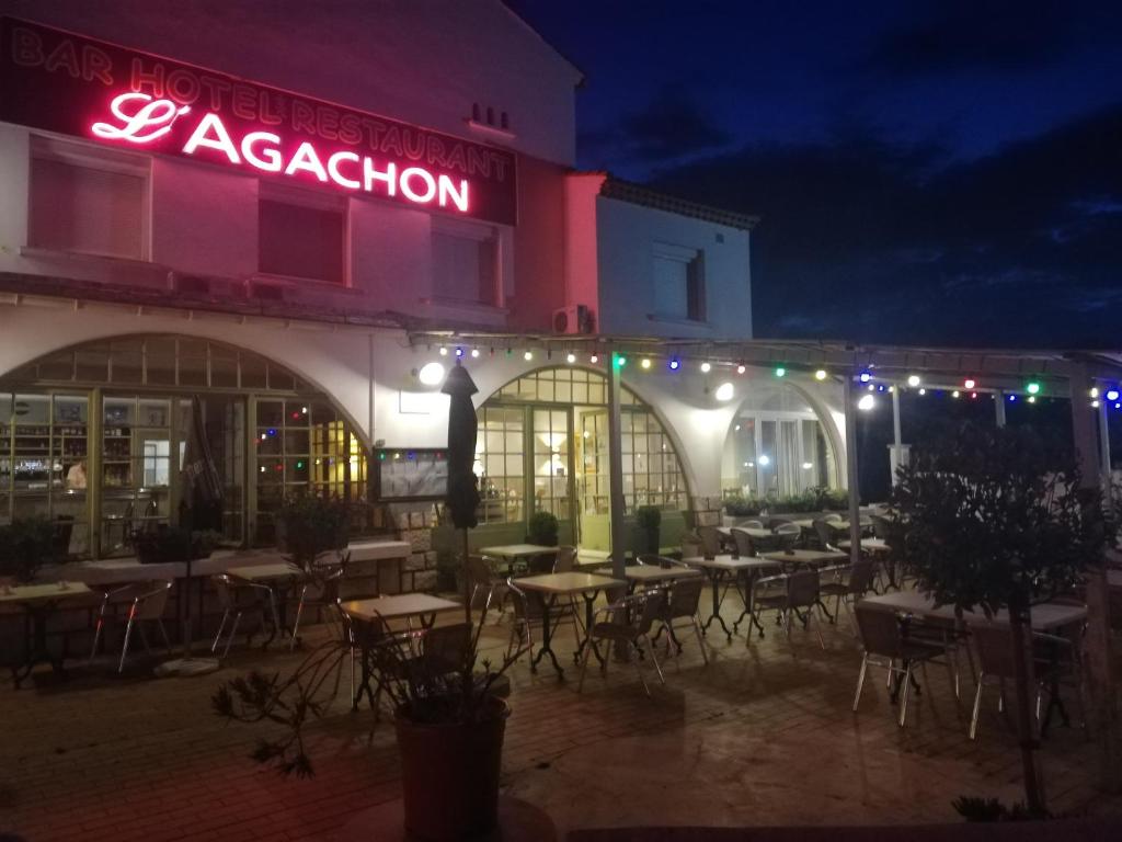 un restaurante con mesas y sillas al aire libre por la noche en Hôtel Restaurant l'Agachon en Albaron