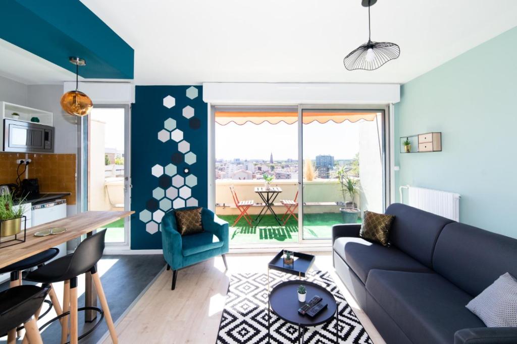 uma sala de estar com um sofá azul e uma mesa em LA TERRASSE DE GATSBY - VUE WOW - Netflix em Toulouse