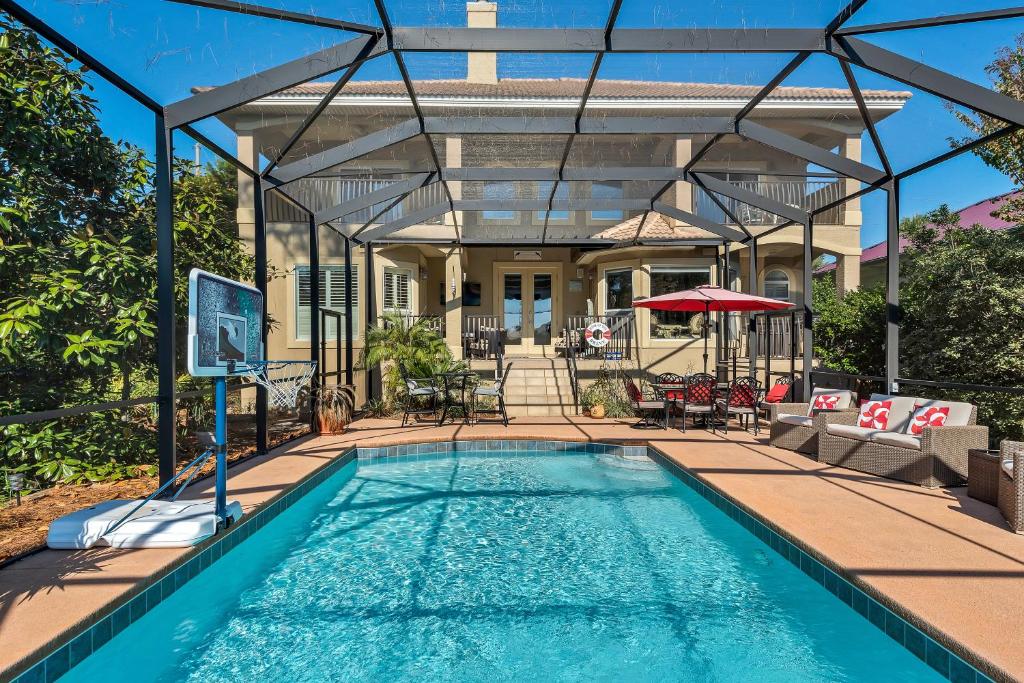 a swimming pool with a pergola next to a house at Casa Isla Paraiso in Destin