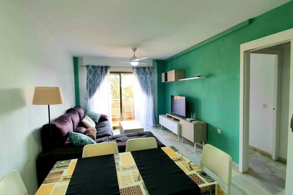- un salon vert avec une table et un canapé dans l'établissement SweetWater Home - Apartamento ideal para tus vacaciones, à El Campillo del Moro