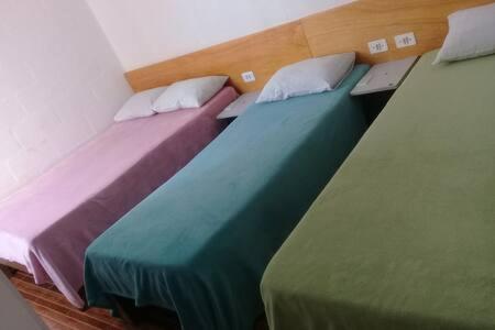 two twin beds in a room with colorful sheets at Villa Maria DA Luz ROCHA CASA D in Olímpia