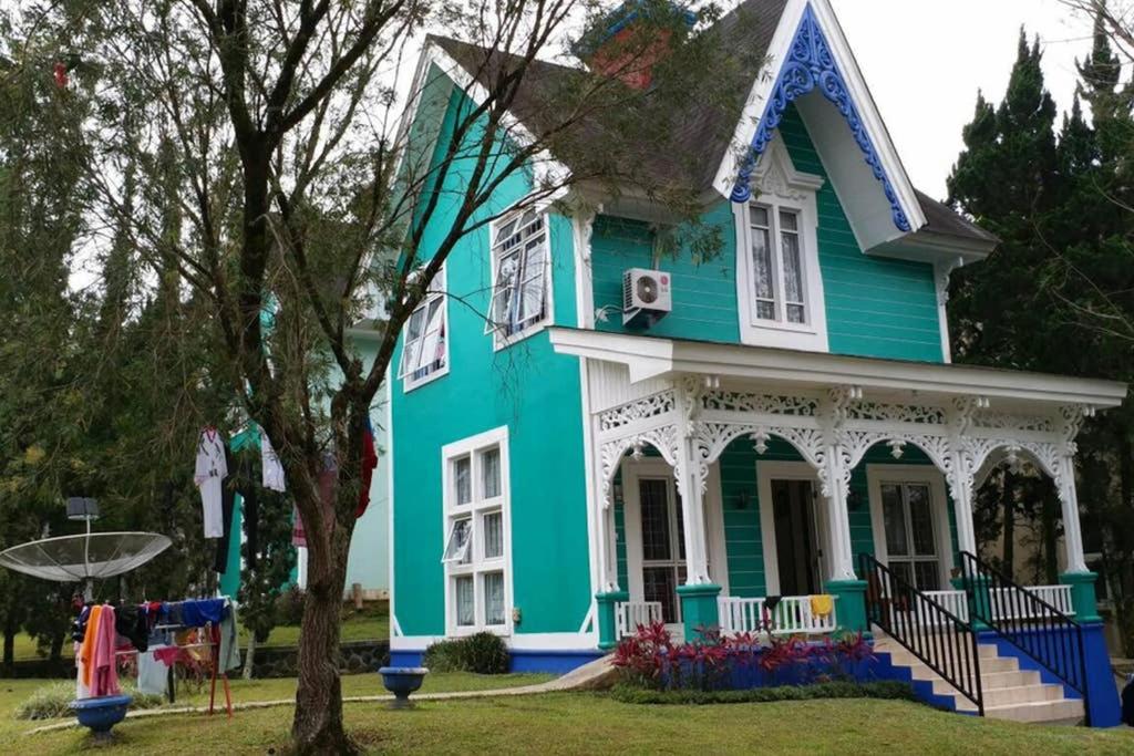 a blue and white house with a tree at Villa Nils in Cianjur