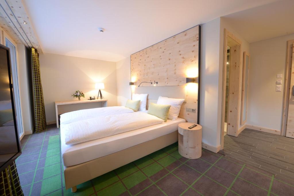 a bedroom with a large white bed in a room at Alpenhotel Fleurs de Zermatt in Zermatt