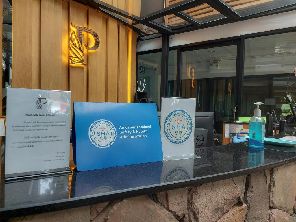 A reception counter displaying hotel information and health-safety certification signs.