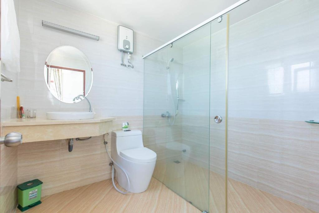 a bathroom with a toilet and a glass shower at Căn hộ Sơn Thịnh - Homestay in Vung Tau