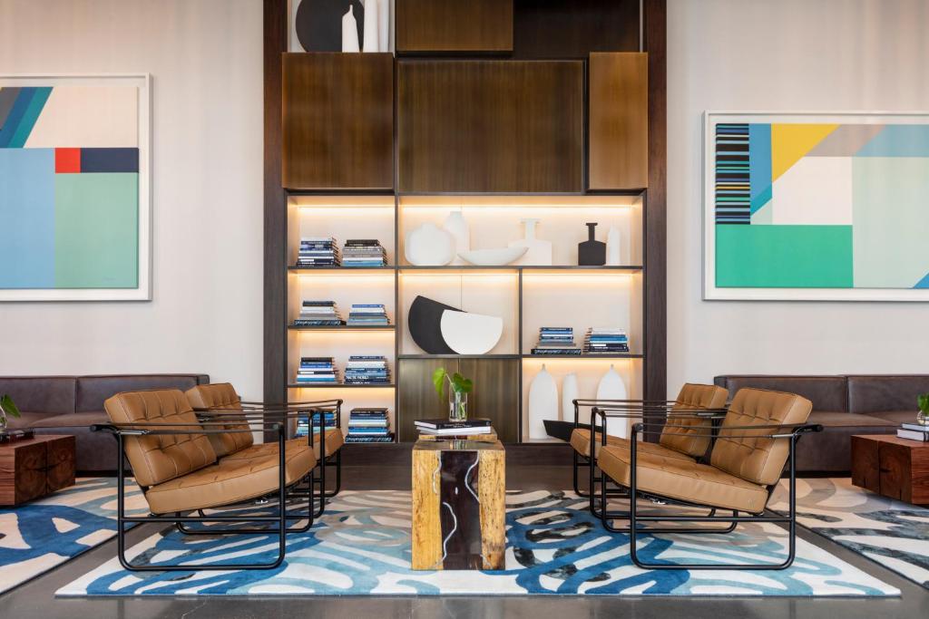 a lobby with chairs and a table and shelves at Kimpton - Pittman Hotel, an IHG Hotel in Dallas