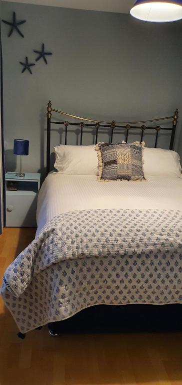 a bedroom with a bed with a black and white comforter at Bay View House in Liscannor