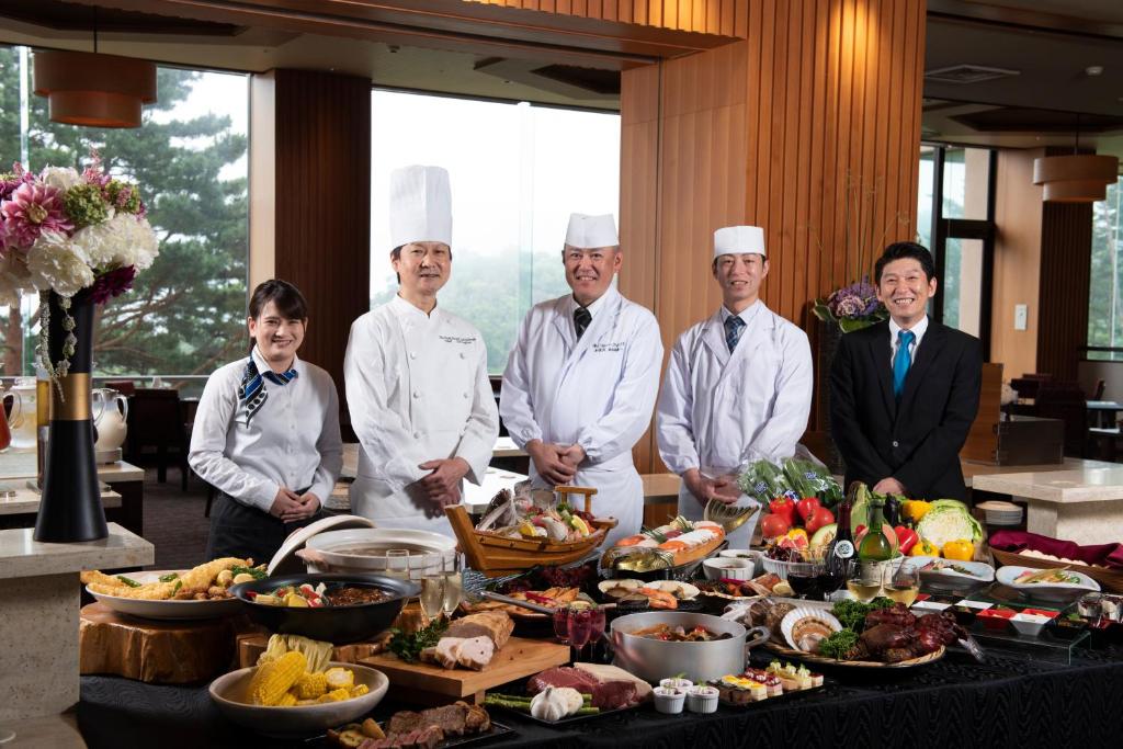 a group of chefs standing in front of a table of food at Jodogahama Park Hotel in Miyako