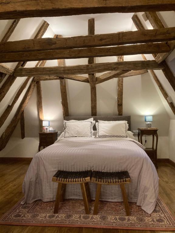 een slaapkamer met een groot bed op een zolder bij Les Petits Cousins Du Québec - Chambres D’hôtes à Domme in Domme