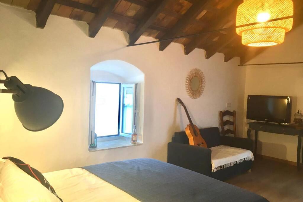 Un dormitorio con una cama y una silla y una ventana. en La Puerta Azul, en Bornos