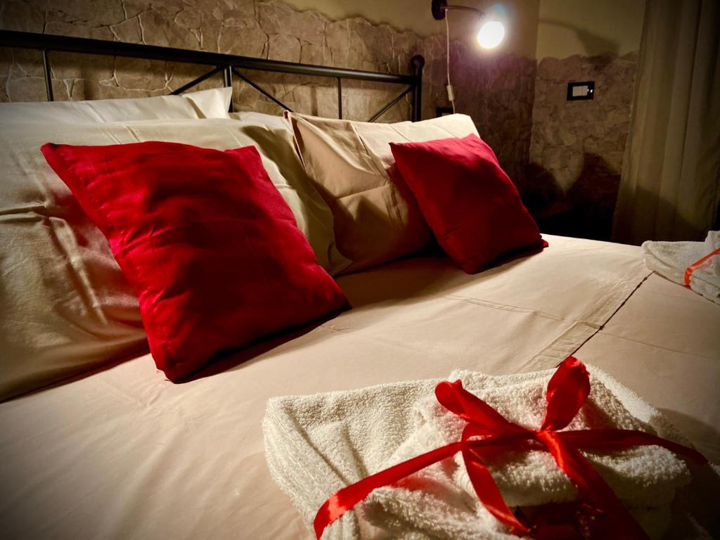 ein Bett mit roten Kissen und einer roten Schleife darauf in der Unterkunft Sweet Rome B&B in Rom