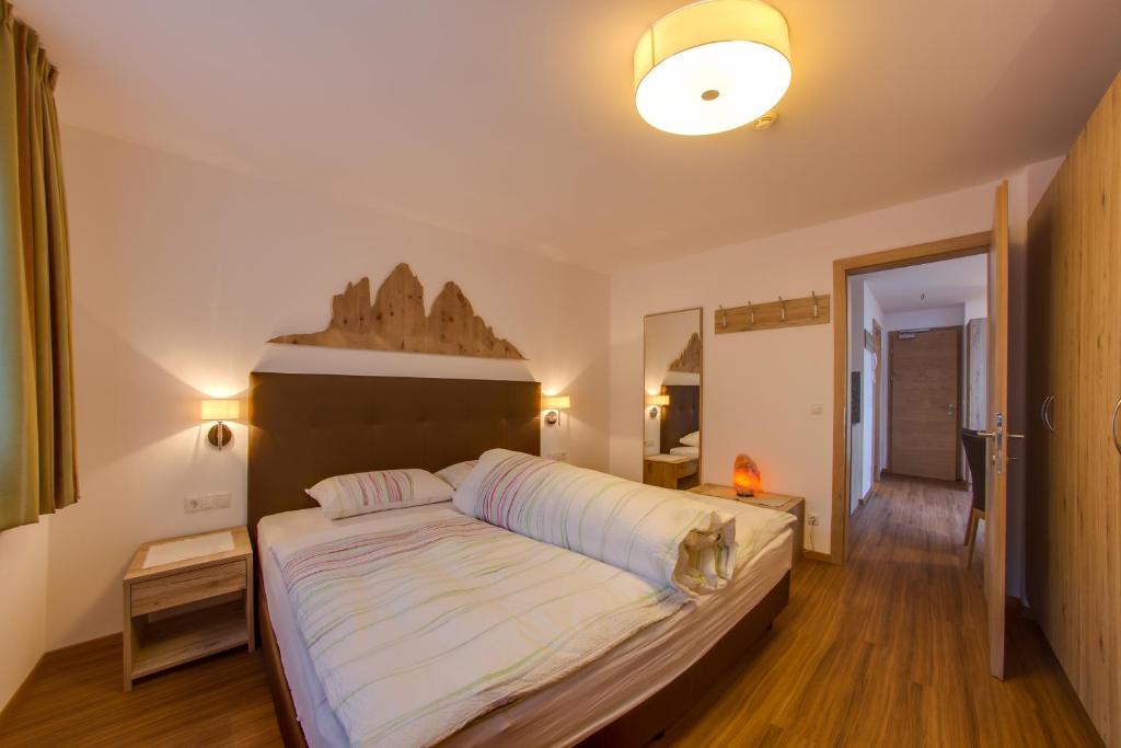 een slaapkamer met een groot bed met een houten hoofdeinde bij Residence Silvia in San Candido