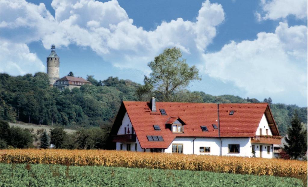 a white house with a red roof in a field at Pension Grünes Herz in Tonndorf